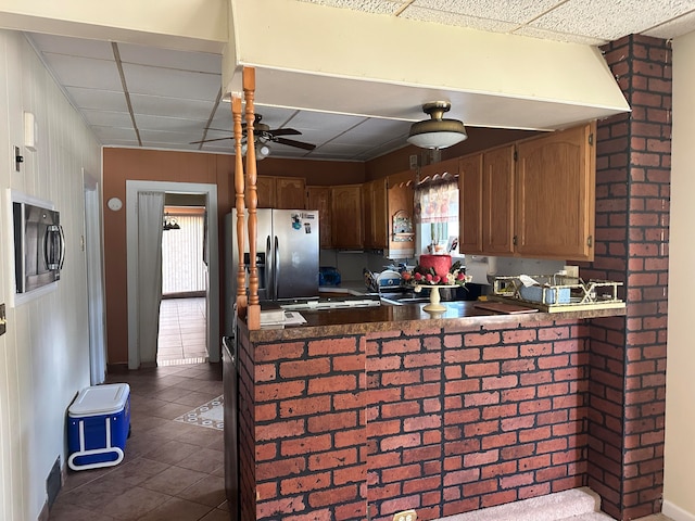 kitchen with a paneled ceiling, kitchen peninsula, and a wealth of natural light