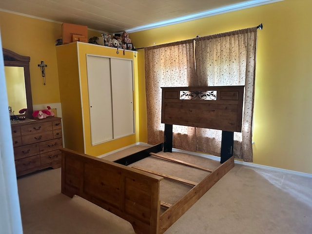 bedroom featuring crown molding, a closet, and light colored carpet