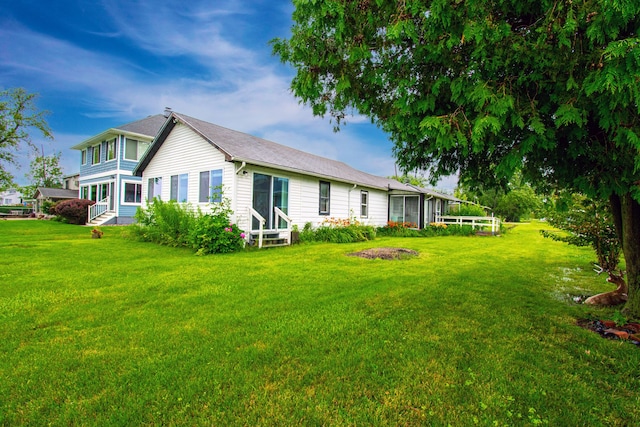 rear view of property with a lawn