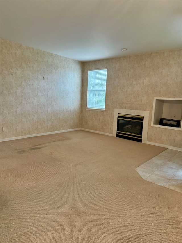 unfurnished living room with a tile fireplace and light colored carpet