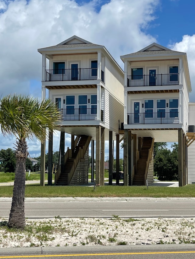 996 W Beach Blvd, Mississippi, MS 39560 - raised beach house featuring a balcony, stairs, and board and batten siding