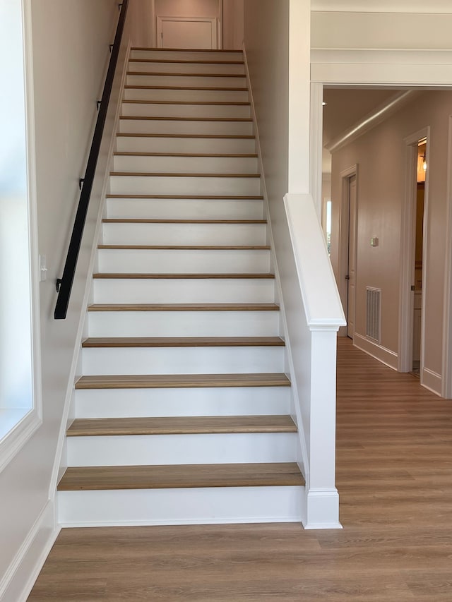 stairs featuring hardwood / wood-style floors