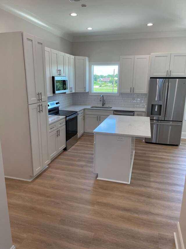 996 W Beach Blvd, Mississippi, MS 39560 - kitchen with stainless steel appliances, a sink, a kitchen island, decorative backsplash, and recessed lighting