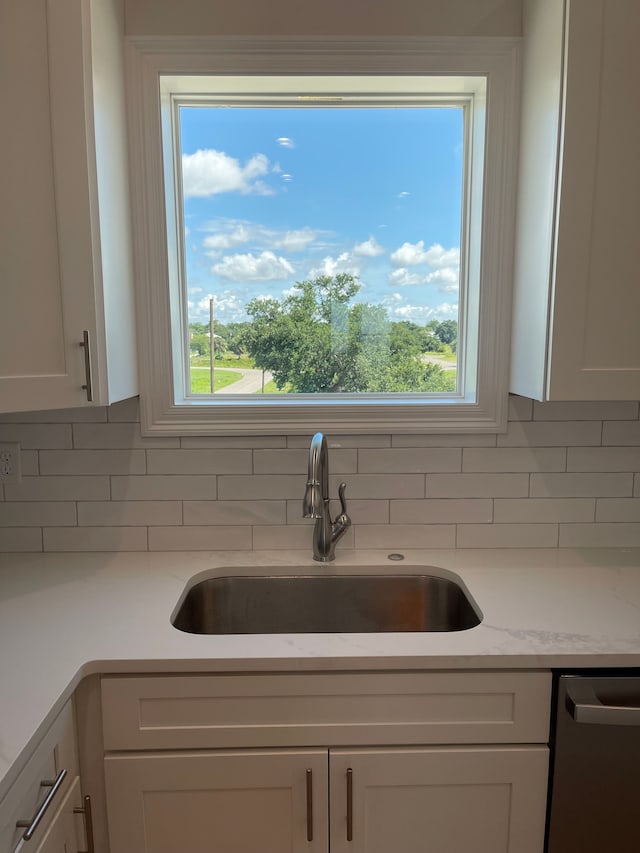 kitchen featuring white cabinets, plenty of natural light, dishwasher, and sink