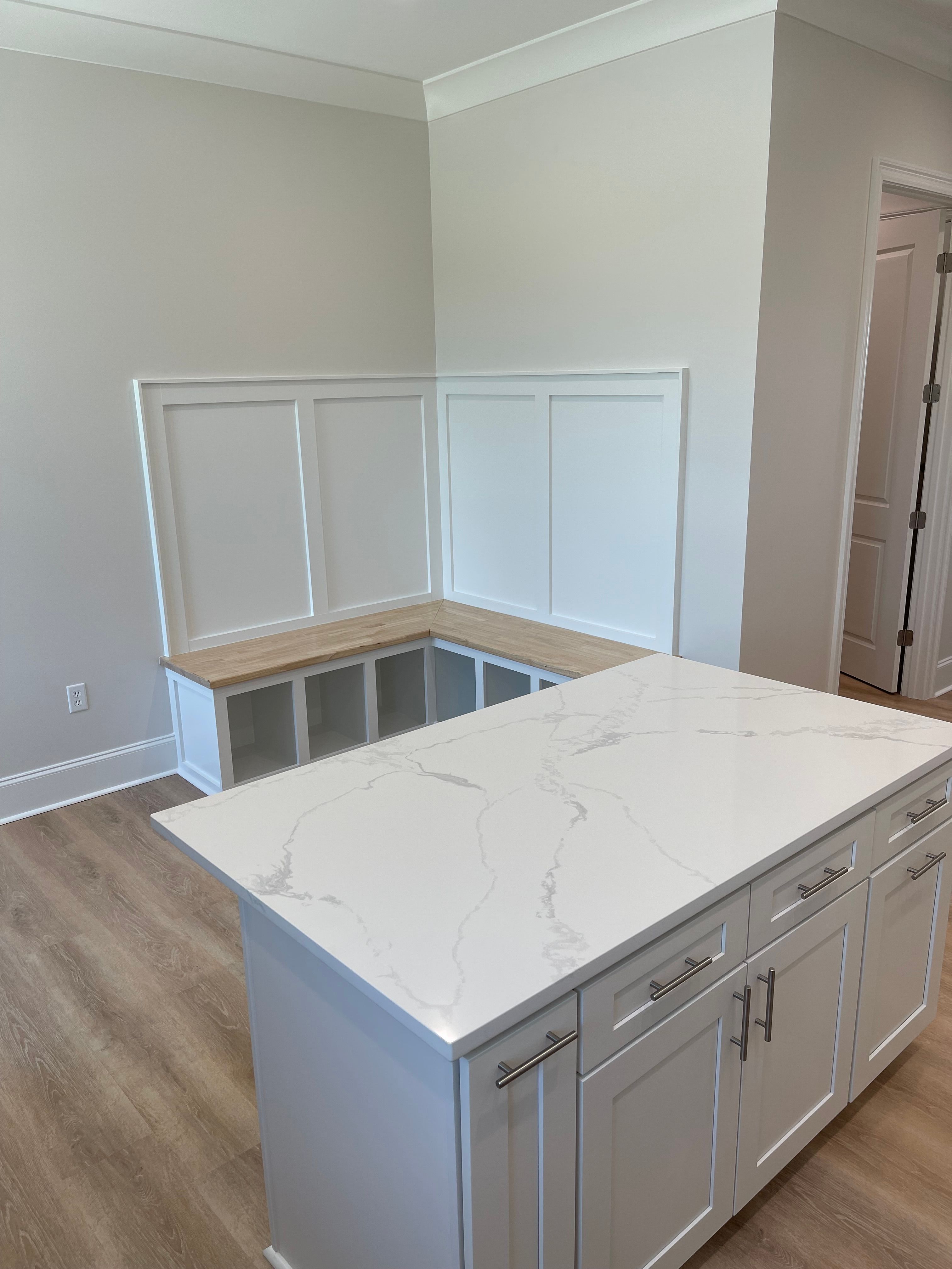 kitchen with a center island, light hardwood / wood-style floors, light stone counters, and ornamental molding