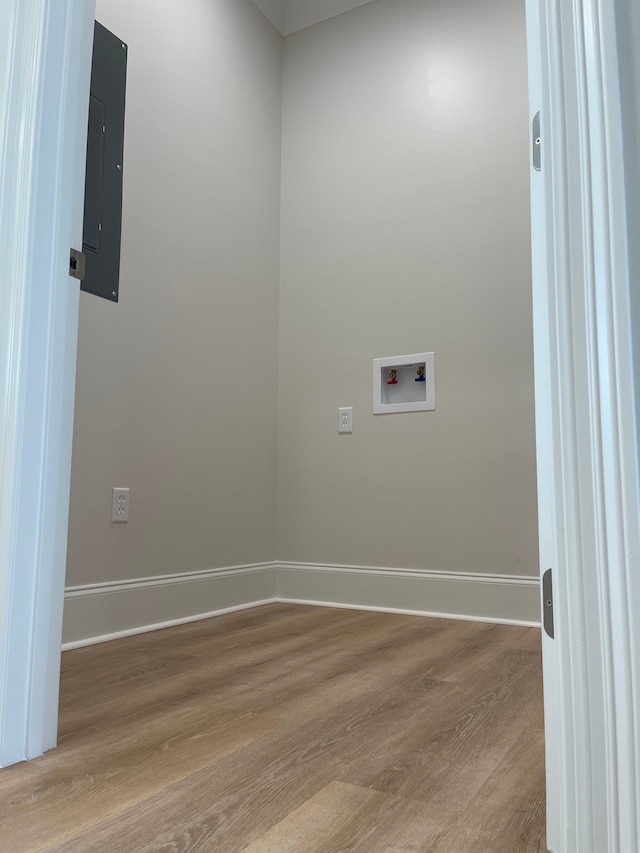 washroom with washer hookup, electric panel, and light hardwood / wood-style floors