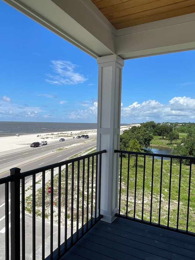 balcony featuring a water view and a beach view