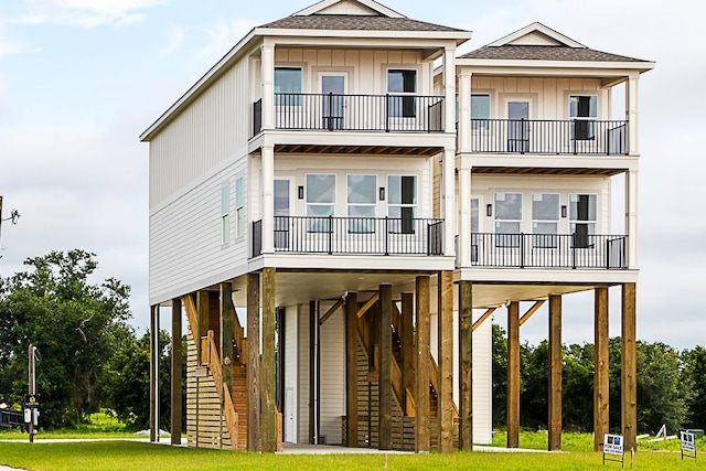 view of front of house with a carport, a balcony, and a front yard