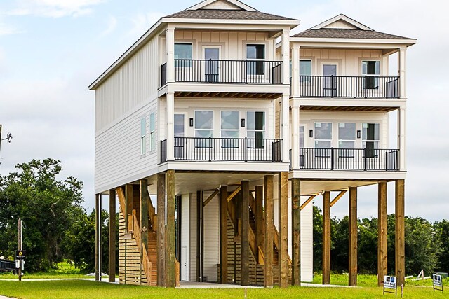 996 W Beach Blvd, Mississippi, MS 39560 - view of front facade with a balcony, roof with shingles, a carport, and board and batten siding