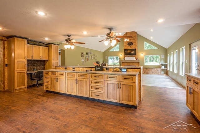 kitchen featuring light stone countertops, ceiling fan, dark hardwood / wood-style flooring, lofted ceiling, and built in desk