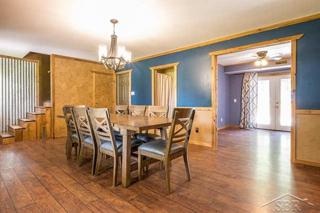 dining space featuring ceiling fan with notable chandelier, ornamental molding, dark wood-type flooring, and french doors