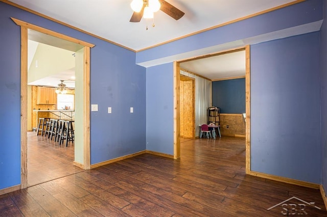 spare room featuring crown molding, ceiling fan, and dark wood-type flooring