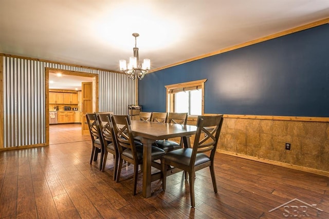 dining room featuring a notable chandelier, crown molding, and dark wood-type flooring