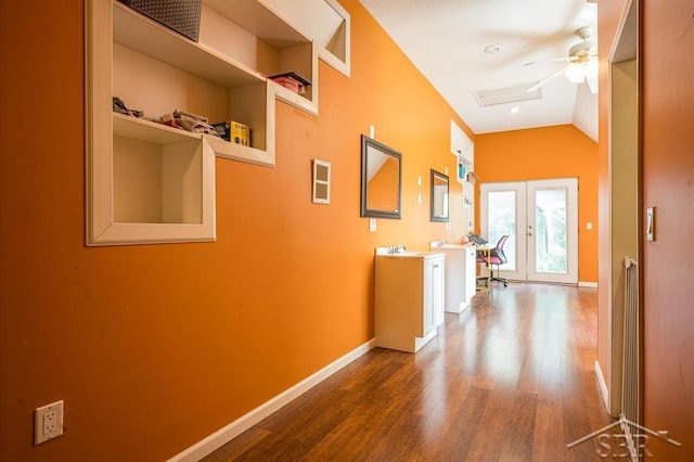 corridor with french doors, hardwood / wood-style floors, and lofted ceiling