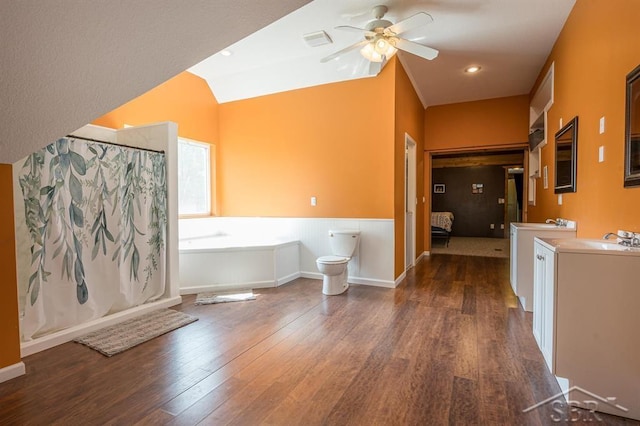 bathroom featuring a tub to relax in, ceiling fan, wood-type flooring, and vaulted ceiling