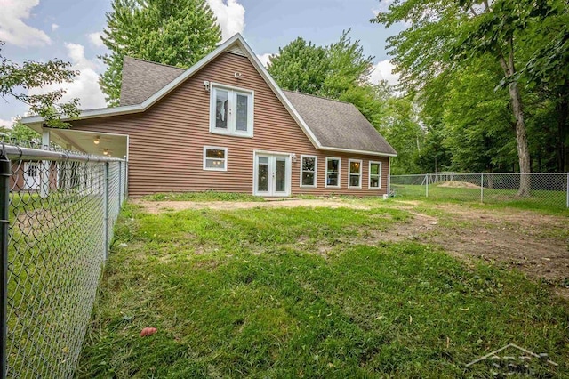 rear view of property with french doors and a lawn