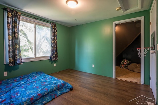 bedroom with multiple windows and hardwood / wood-style flooring