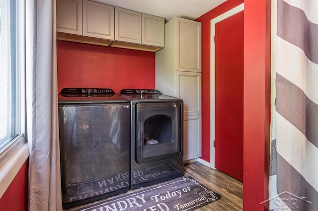 laundry room with cabinets, washer and clothes dryer, and dark wood-type flooring