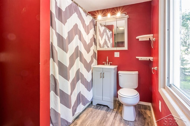 bathroom featuring vanity, hardwood / wood-style flooring, toilet, and walk in shower