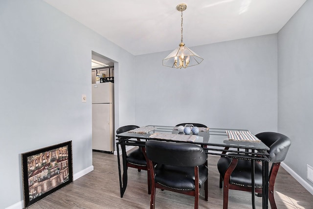 dining area featuring a chandelier and wood-type flooring