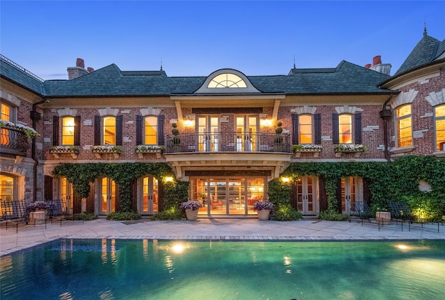 back house at dusk with a balcony