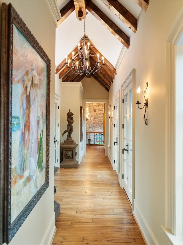 hall with french doors, lofted ceiling with beams, light hardwood / wood-style floors, and a notable chandelier