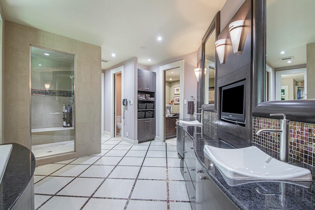 bathroom with tile patterned floors, vanity, and a shower with door