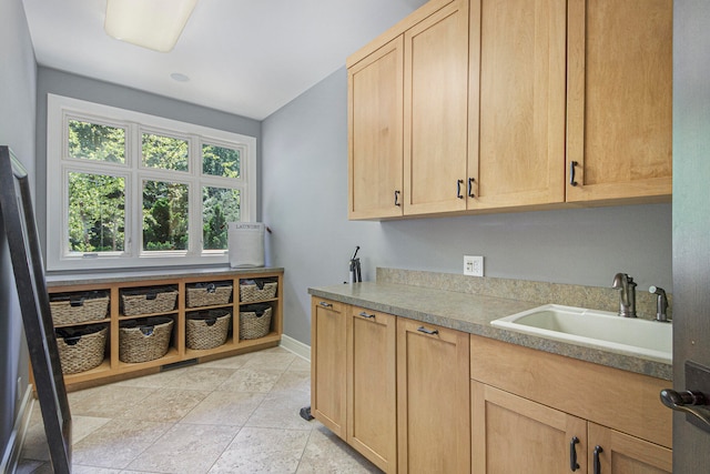 kitchen with light brown cabinetry, sink, and light tile patterned floors