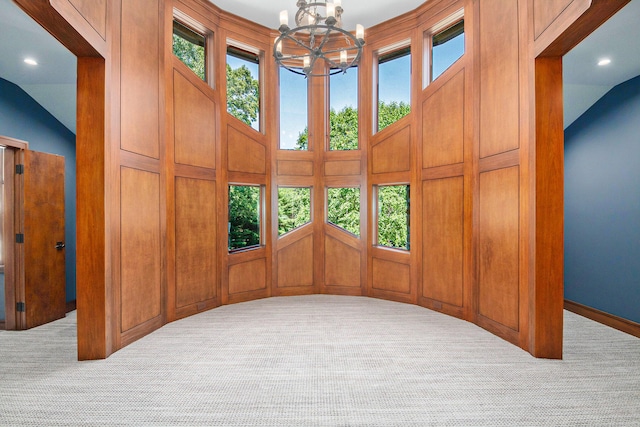 interior space featuring a chandelier, light colored carpet, and vaulted ceiling