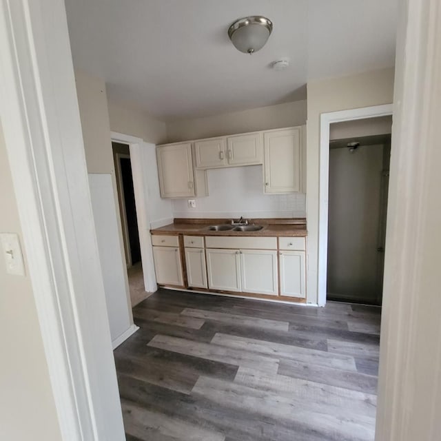 kitchen with white cabinets, hardwood / wood-style floors, butcher block counters, and sink