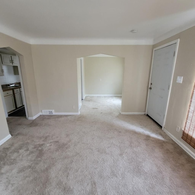 unfurnished living room with light colored carpet