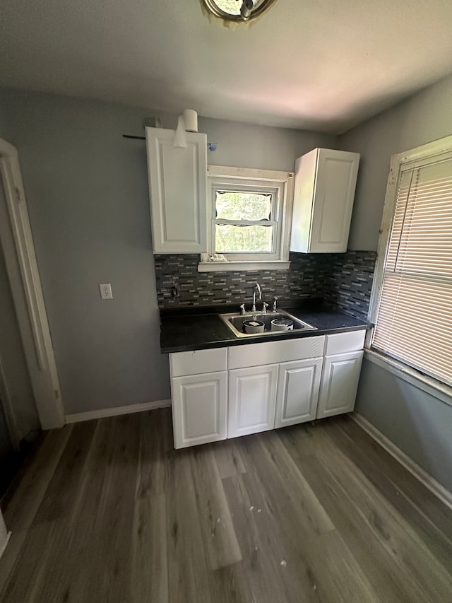 kitchen featuring white cabinets, tasteful backsplash, dark wood-type flooring, and sink