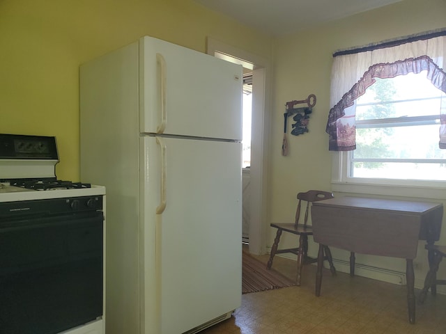 kitchen with gas stove, freestanding refrigerator, and tile patterned floors