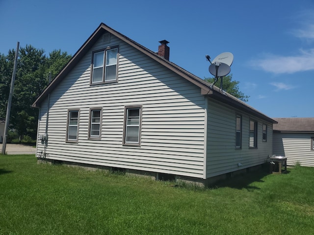 view of home's exterior featuring a yard and a chimney