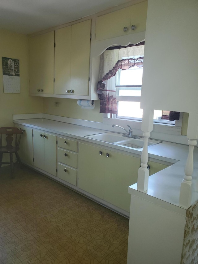 kitchen featuring light countertops, a sink, and tile patterned floors