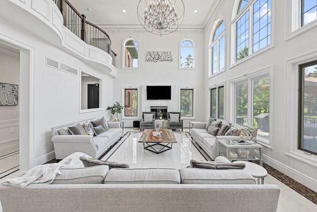 living room featuring wood-type flooring, a high ceiling, a wealth of natural light, and ornamental molding