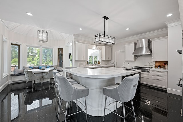 kitchen featuring decorative backsplash, white cabinetry, hanging light fixtures, and wall chimney exhaust hood