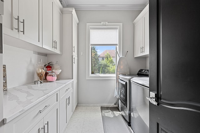 washroom featuring light tile patterned flooring, cabinets, independent washer and dryer, and crown molding