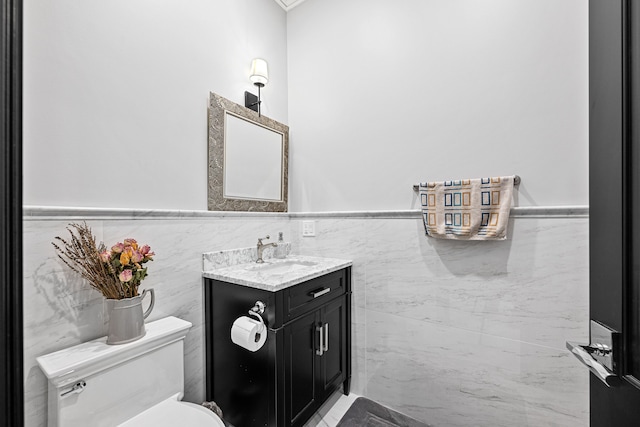 bathroom with vanity, tile walls, and toilet