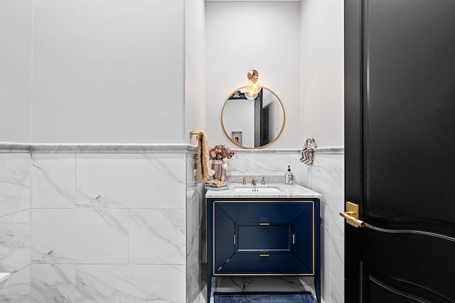 bathroom with vanity and tile walls