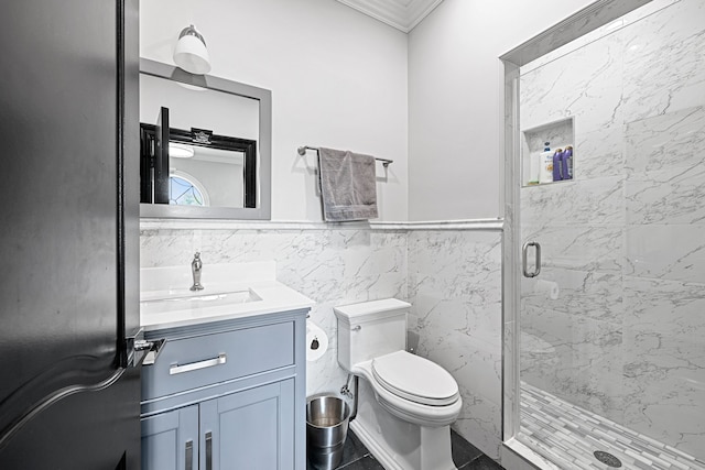 bathroom with vanity, a shower with door, tile patterned flooring, toilet, and tile walls