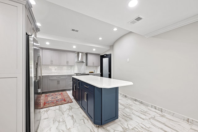 kitchen with gray cabinetry, a center island, wall chimney range hood, tasteful backsplash, and stainless steel refrigerator with ice dispenser