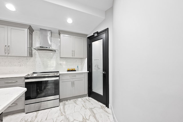 kitchen featuring gray cabinetry, wall chimney exhaust hood, stainless steel electric range, and decorative backsplash