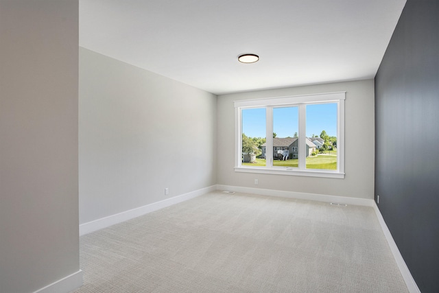 spare room featuring light colored carpet