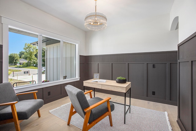 office area with light hardwood / wood-style floors and an inviting chandelier