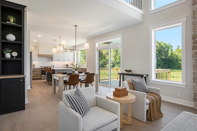 living room featuring a notable chandelier, plenty of natural light, and light hardwood / wood-style flooring