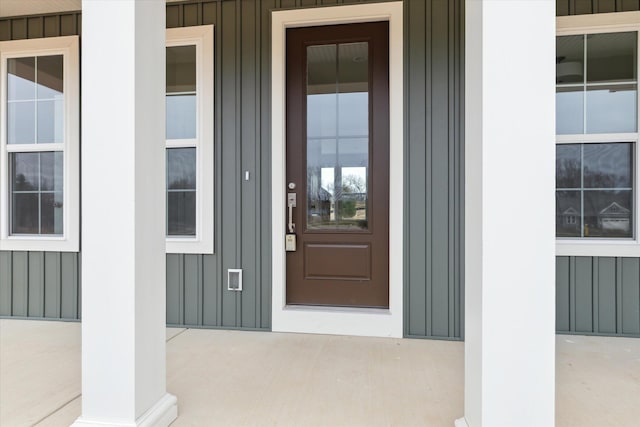 property entrance with board and batten siding and a porch