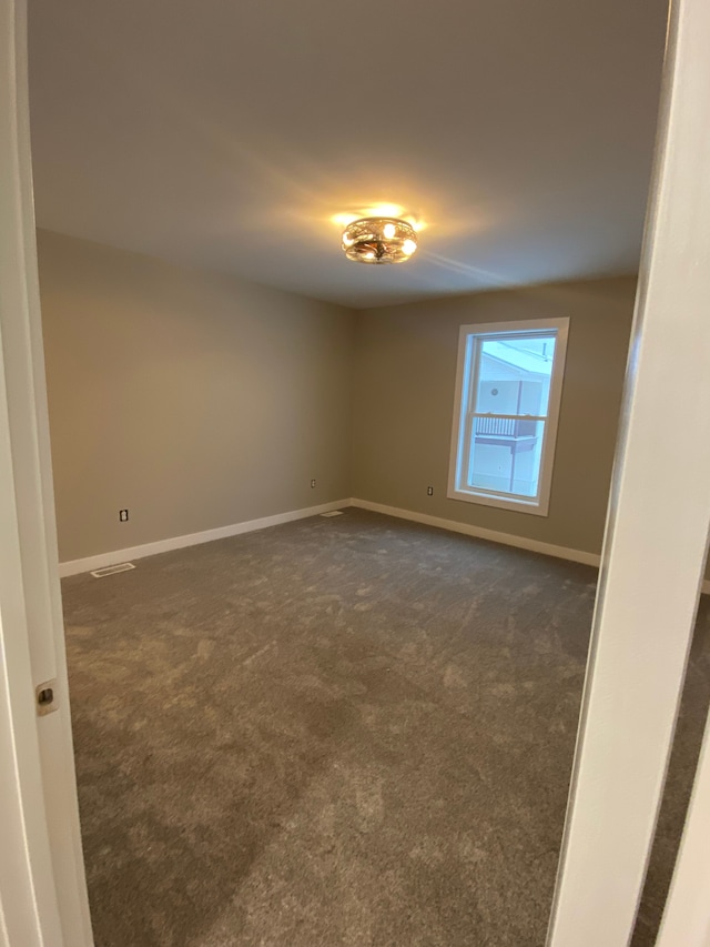 empty room with dark colored carpet