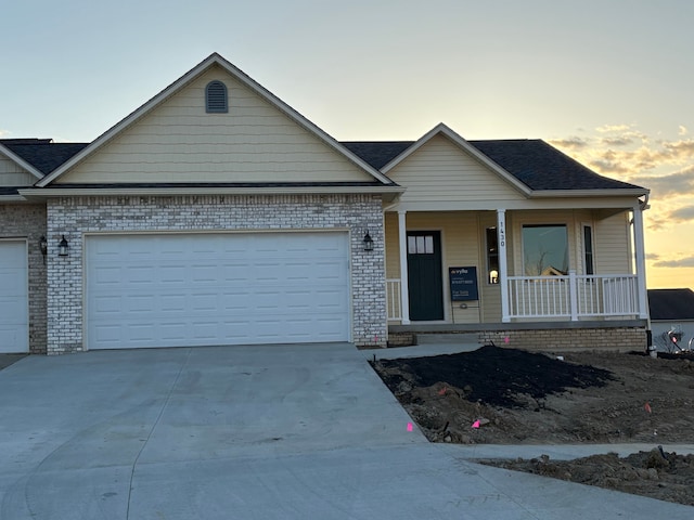 1430 N Mallard Cir, Owosso, MI 48867 - view of front facade with a garage, brick siding, a porch, and driveway