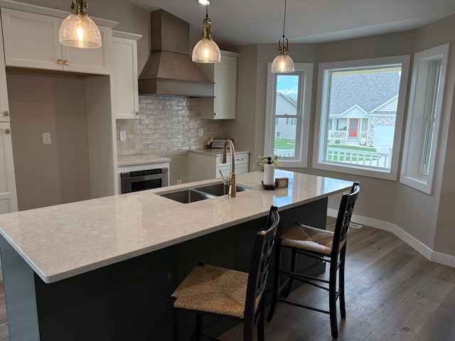 1430 N Mallard Cir, Owosso, MI 48867 - kitchen featuring custom exhaust hood, backsplash, wood-type flooring, a sink, and baseboards